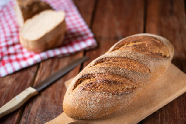 istock Composition of freshly baked bread on old wooden background 1346583802