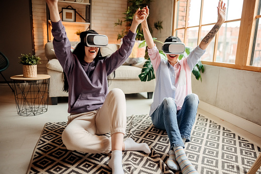 Mother and daughter using virtual reality headsets at home