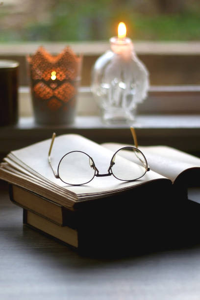 istock Book, Reading Glasses, Candles and Flowers 1346587859