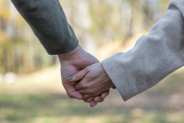 istock Couple holding hands in autumn nature background 1346592185