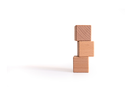 Three empty wooden cubes piled on top of each other against a white background