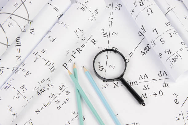 istock rolls of paper drawings with math electrical formulas, magnifier and pencils 1346599899