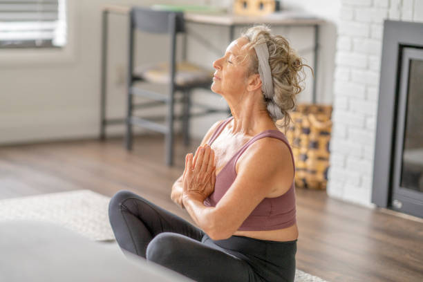 istock Senior Woman Meditating at Home 1346600321