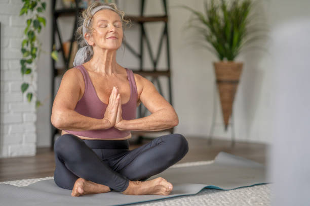 istock Senior Woman Meditating at Home 1346600322