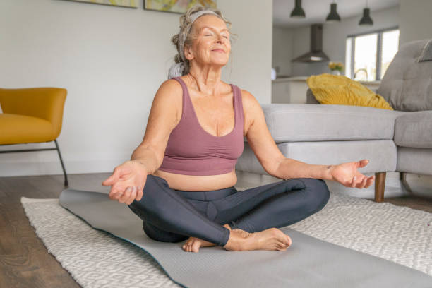 istock Senior Woman Meditating at Home 1346600336