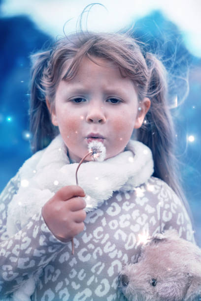 istock Little girl blowing a dandelion 1346605990