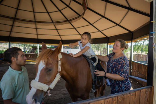 la ragazza con autismo riceve una terapia con i cavalli in un centro privato. - teaching child horseback riding horse foto e immagini stock