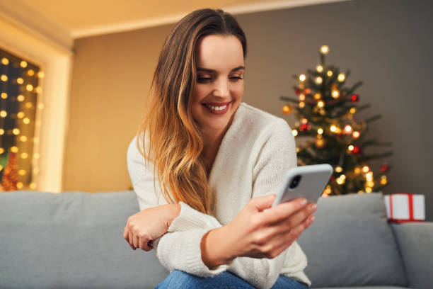 istock Alone woman at home during Christmas using mobile phone 1346607848