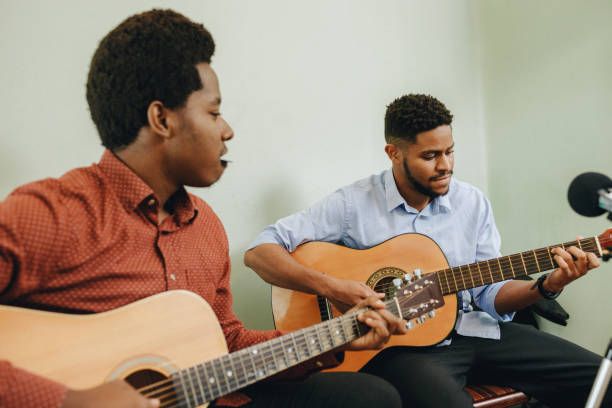 istock Two young African-Americans playing musical instruments at home 1346610053