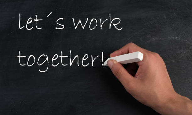 istock Lets work together is standing on a chalkboard, handwritten with white chalk 1346610347
