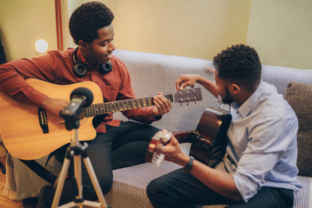 istock Two young African-Americans playing musical instruments at home 1346610468