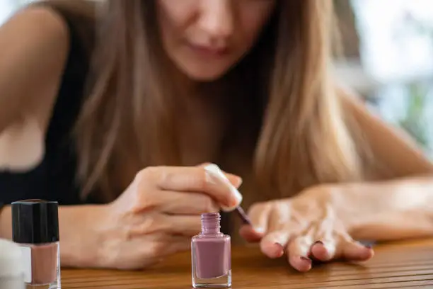 Photo of Young Woman Applying Nail Polish at Home