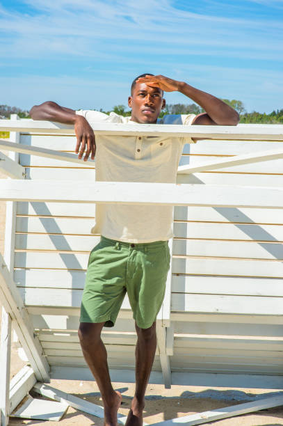 istock Young black man standing on beach, relaxing 1346611480