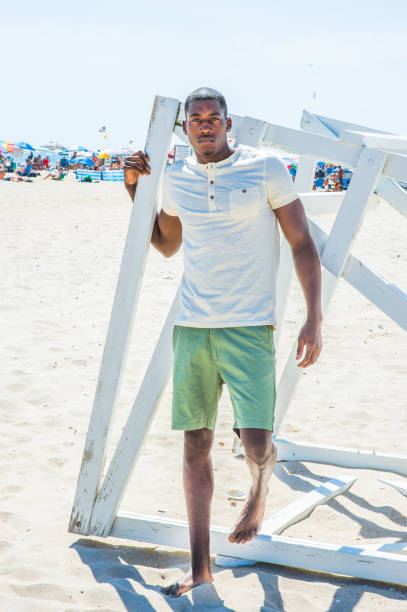 istock Young black man standing on beach, relaxing 1346611494