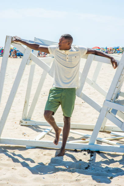 istock Young black man standing on beach, relaxing 1346611503