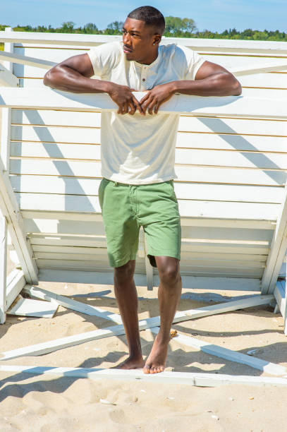 istock Young black man standing on beach, relaxing 1346611538