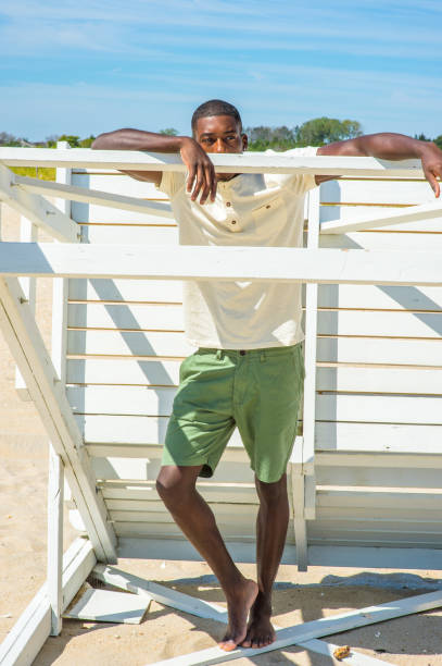 istock Young black man standing on beach, relaxing 1346611576