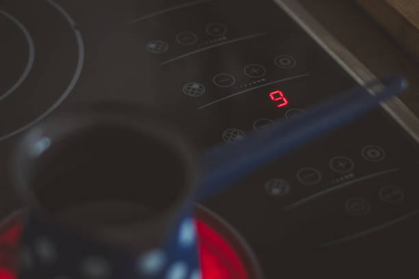 istock Detail of numer 9, maximum heat setting on modern glass or ceramic cooking board while heating a jar of water. 1346611724