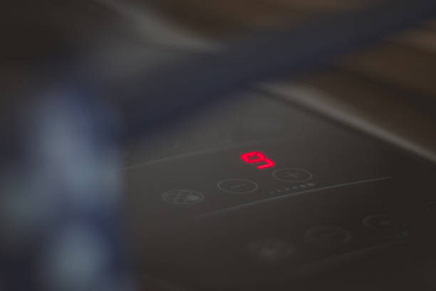 istock Detail of numer 9, maximum heat setting on modern glass or ceramic cooking board while heating a jar of water. 1346611744