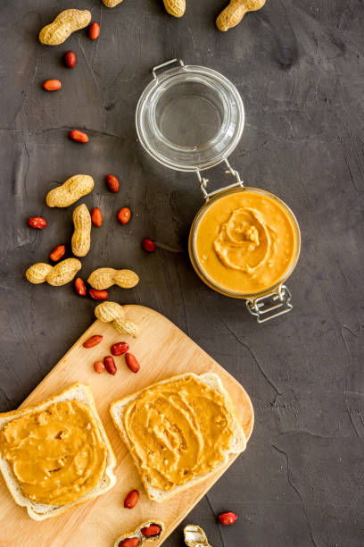 istock Smooth peanut butter on sandwiches with nuts. Top view 1346613903