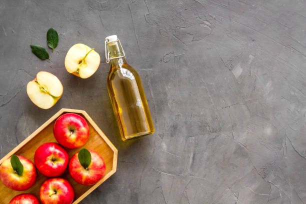 istock Bottle of organic apple cider vinegar with red apples 1346614042