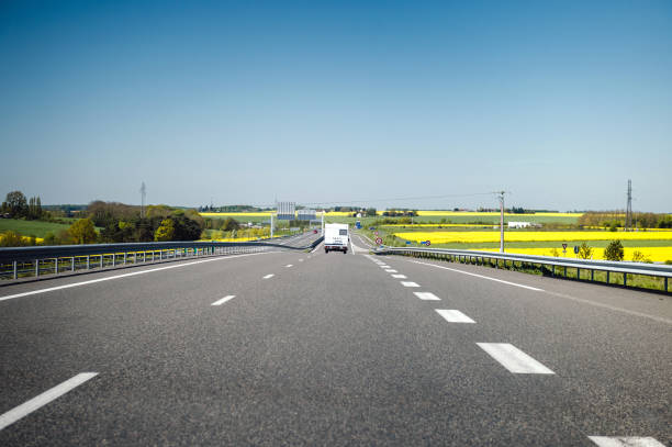 Camper RV van driving fast on French highway toward holiday destination and clear blue sky
