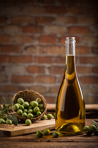 Bottle of extra virgin olive oil on a table with concrete wall backgound