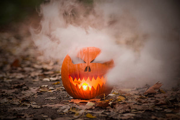 istock Halloween pumpkin lantern with smoking eyes and light mouth. 1346619564