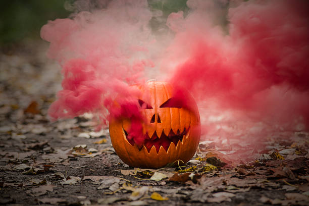 istock Halloween pumpkin lantern with smoking eyes and light mouth. 1346619572