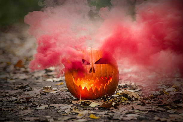 istock Halloween pumpkin lantern with smoking eyes and light mouth. 1346619585