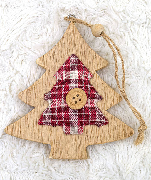 istock Wooden Christmas tree pendant decoration with textile elements on white fur background 1346619625