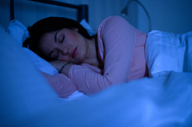 istock Woman sleeping in her bed while her smartphone is still on 1346621929
