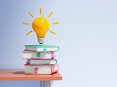Light bulb over the stack of colorful books