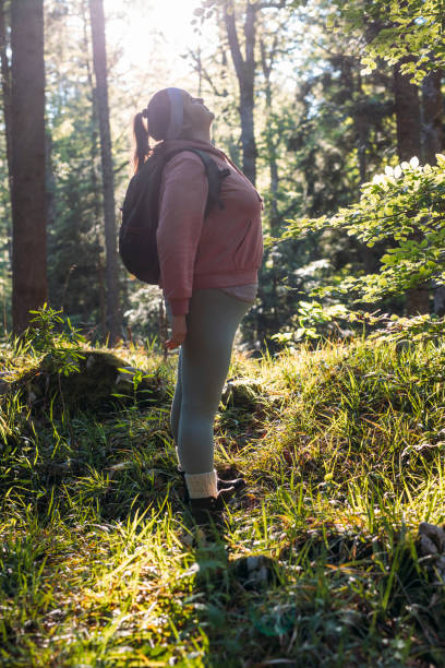 istock Plus Size Woman in a Pink Sweatshirt Standing in the Forest 1346623716