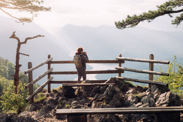 una excursionista anónima de pie en un mirador de alta montaña y tomando una fotografía con su cámara - splash mountain fotografías e imágenes de stock