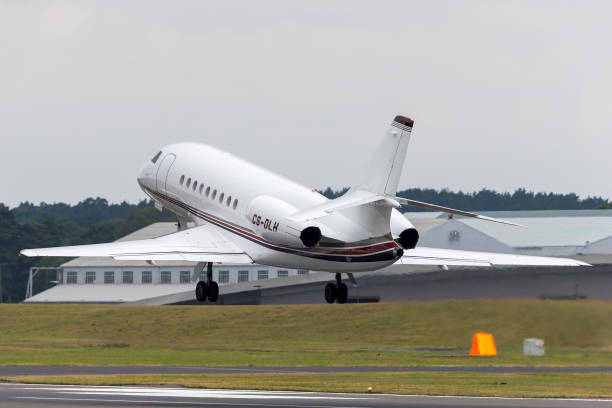 самолет netjets dassault falcon взлетает из аэропорта фарнборо - falcon стоковые фото и изображения