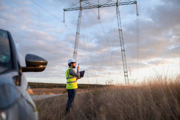 инженер, работающий на линии электропередачи в полевых условиях. - telecommunications equipment стоковые фото и изображения