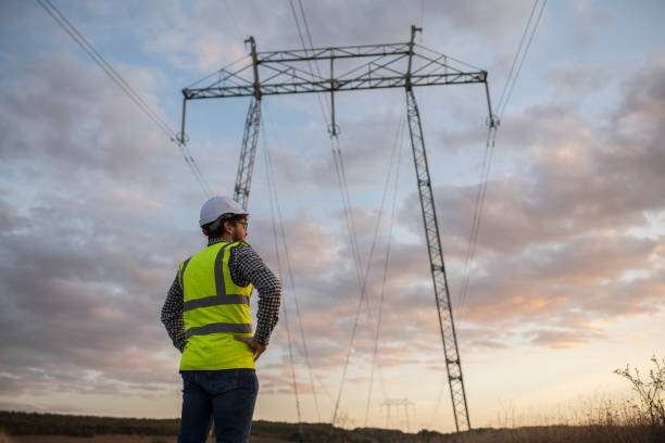 istock Engineer Standing Around Power Line In Field At Sunset. 1346636670