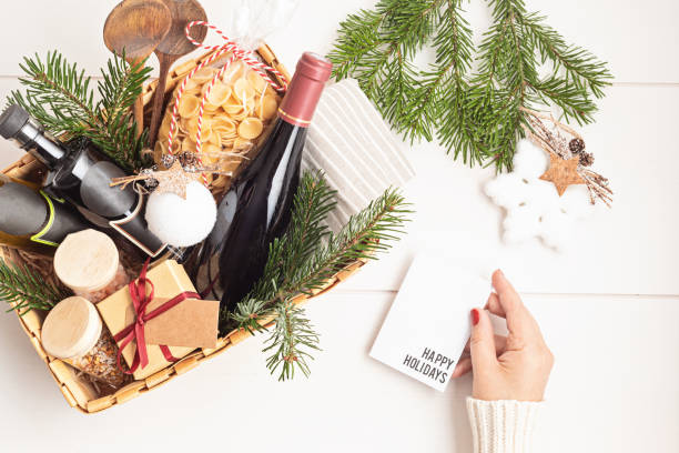 ワインのボトルとイタリアのキュシンの食材を使った料理の熱狂のための洗練されたクリスマスギフトバスケット - wine culture ストックフォトと画像