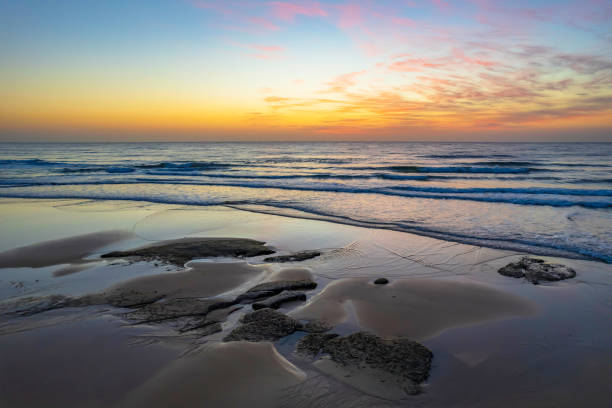 istock Aerial sunrise seascape with high cloud and gentle surf 1346640721