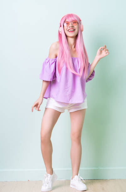 Young Asian woman with pink hair posing on green background