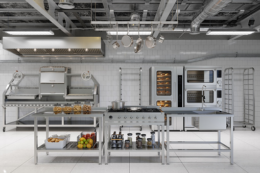 Vista frontal del interior de la cocina industrial moderna con utensilios de cocina, equipos y productos de panadería photo