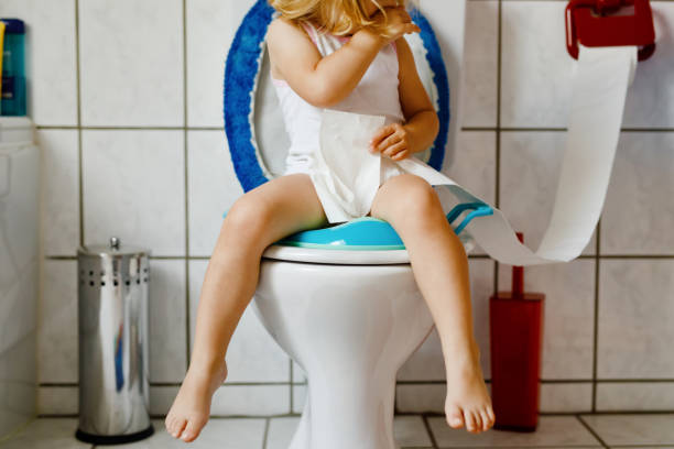 Closeup of cute little toddler baby girl child sitting on toilet wc seat. Potty training for small children. Unrecognizable face of child Closeup of cute little toddler baby girl child sitting on toilet wc seat. Potty training for small children. Unrecognizable face of child. potty toilet child bathroom stock pictures, royalty-free photos & images