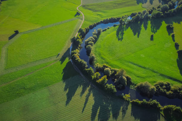 vista aérea da unica ou rio unec no campo de planinsko polje no final do verão. campos verdes e florestas vistas de cima. - planinsko polje - fotografias e filmes do acervo