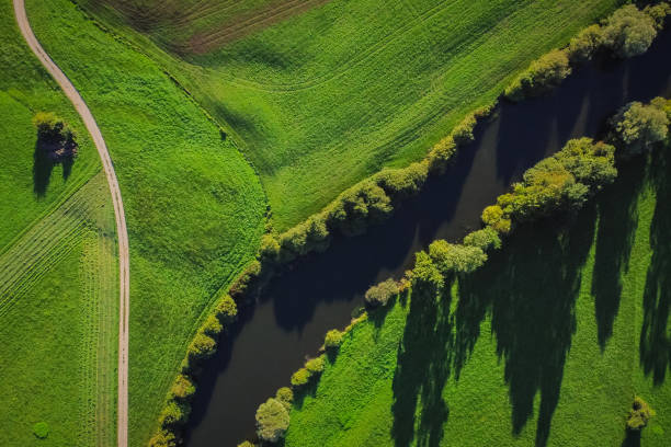 vista aérea vertical do rio unica ou unec no campo de planinsko polje no final do verão. campos verdes e florestas vistas de cima. - planinsko polje - fotografias e filmes do acervo