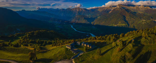 istock Panorama from Kolovrat mountain down towards Soca valley and Kobarid. Dark and cold Soca valley opposed to sunlit mountains above it. 1346671236