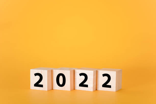 istock Wooden cubes on a yellow background and 2022. 1346672253