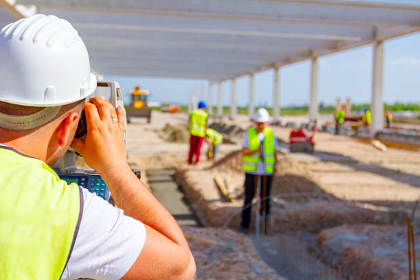 Civil engineer, geodesist is working with total station on a building site Zrenjanin, Vojvodina, Serbia - April 26, 2018: Surveyor engineer is measuring level on construction site. Surveyors ensure precise measurements before undertaking large construction projects. la geode stock pictures, royalty-free photos & images