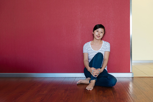 Young woman sitting in front of wall