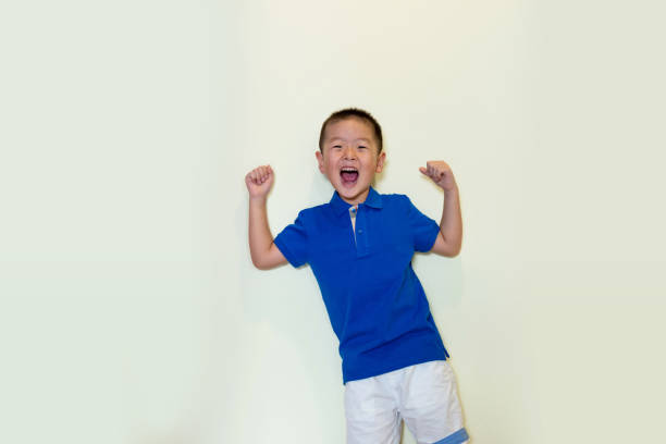 маленький мальчик показывает свои бицепсы - flexing muscles little boys human muscle strength стоковые фото и изображения